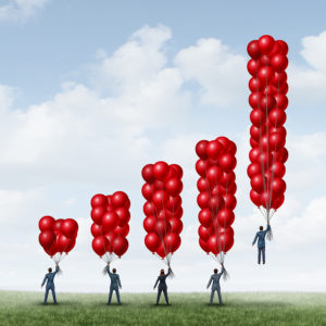 an illustration of 5 business men holding balloons with the number of balloons increasing in an upward trend graph