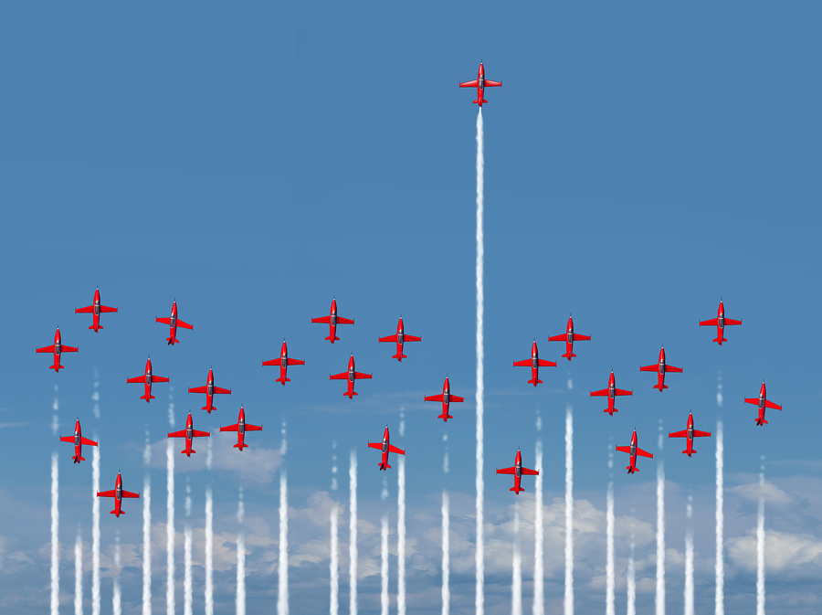multiple red jets flying in a line with one ahead of the pack